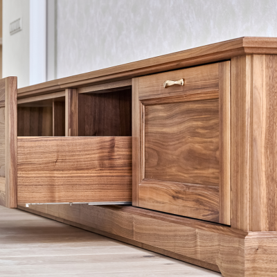 elegant-new-tv-cabinet-made-veneer-solid-walnut-lumber-with-open-drawer-low-angle-view